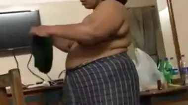 Fat Indian woman with big belly walks around the house with naked boobs